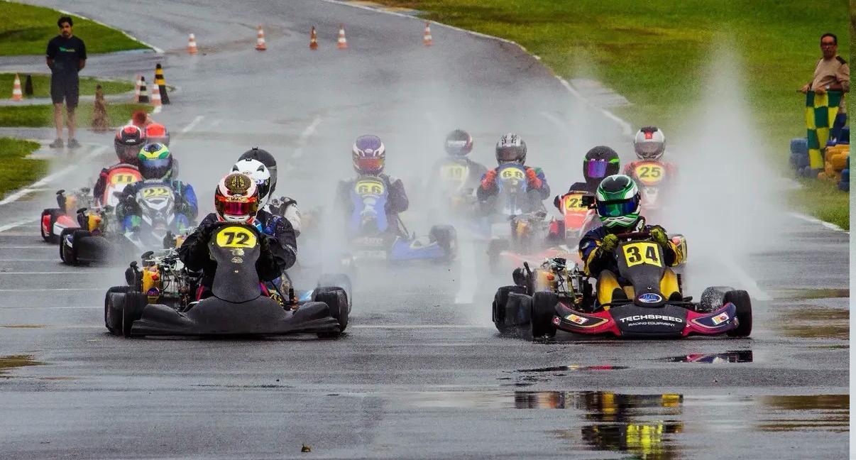 Largada de karts com pista molhada e respingos de água